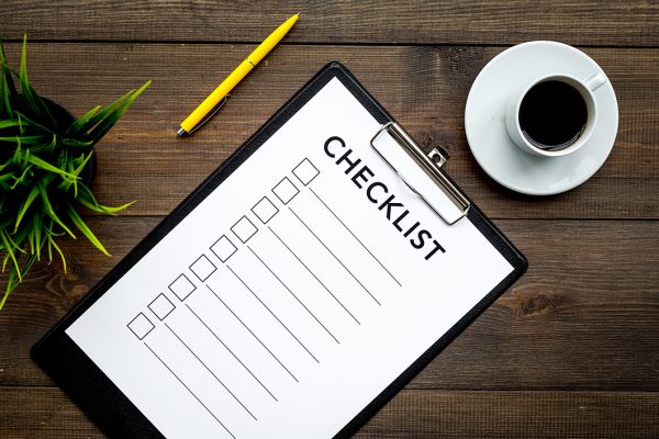 Blank checklist with space for ticks on pad on office desk. Checklist for office worker, manager, businessman, chief on dark wooden background top view Blank checklist with space for ticks on pad on office desk. Checklist for office worker, manager, businessman, chief on dark wooden background top view.